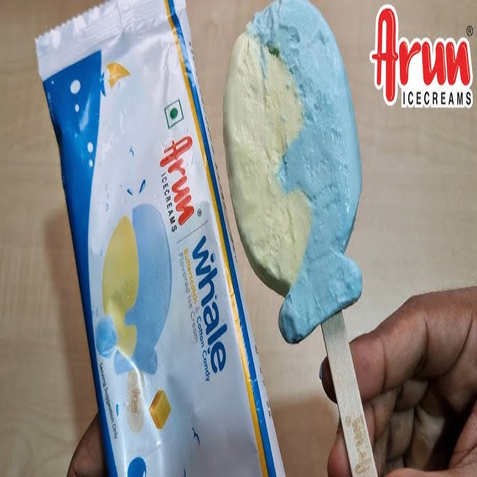 Ice cream bar shaped like a whale with Arun Icecreams packaging on a wooden surface