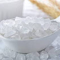 White bowl filled with ice cubes on a white background